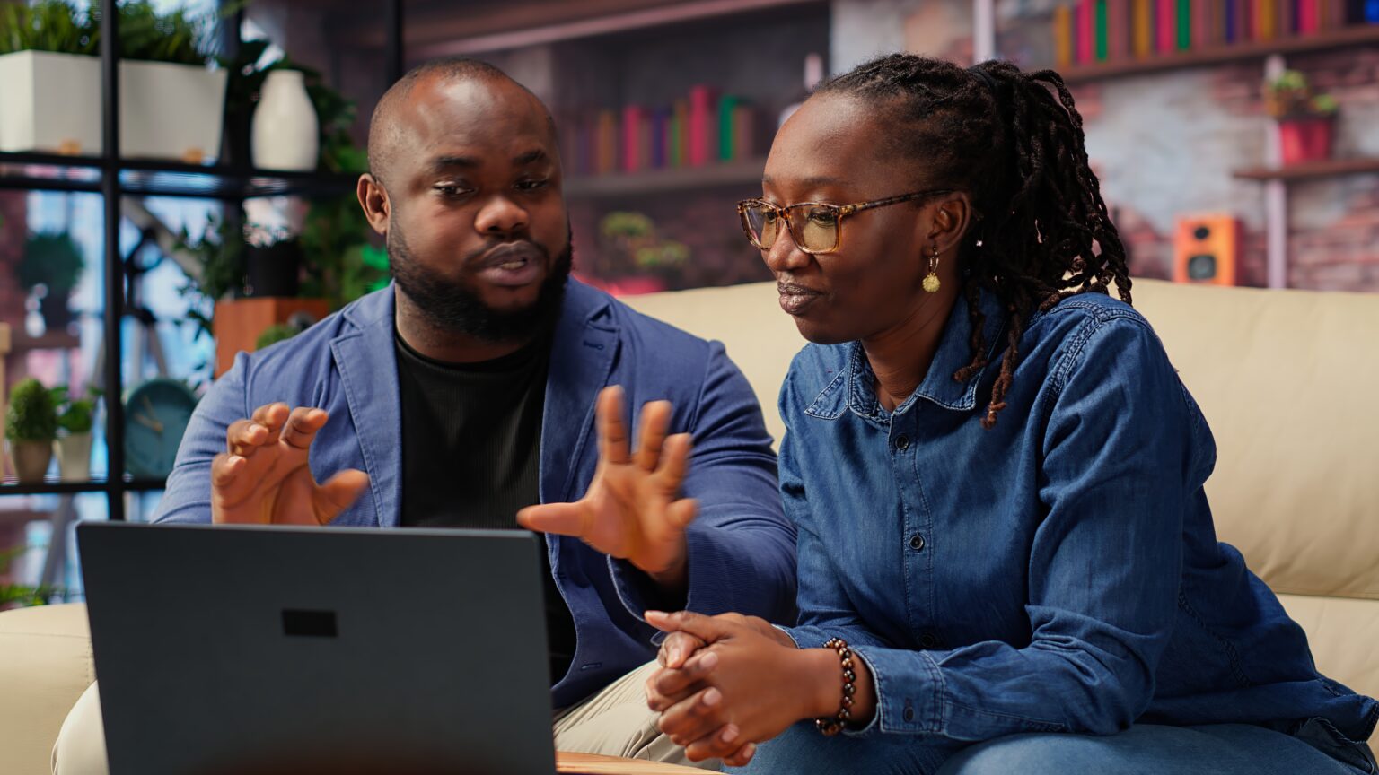 Black young couple attending an online video call connection at home